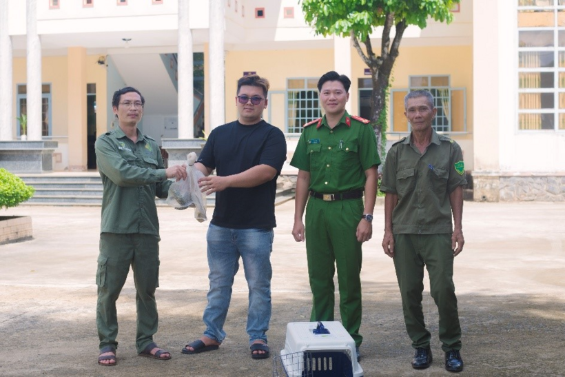 Anh Hào tự nguyện giao nộp cá thể Kỳ đà vân cho Công an xã. (Ảnh: Công an TP.Đồng Nai)