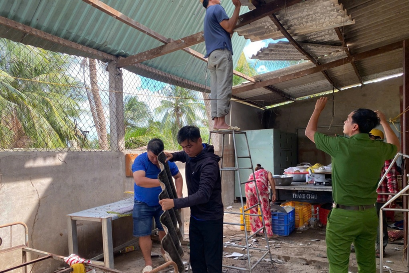 Lực lượng chức năng hỗ trợ người dân sửa mái nhà bị tốc. (Ảnh: Dân trí)