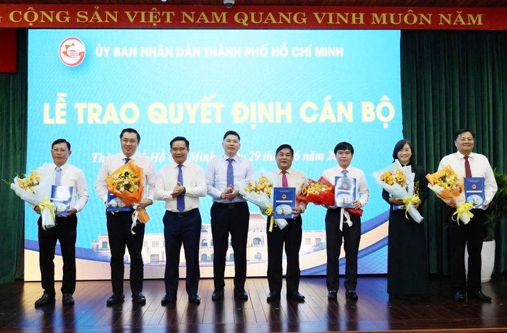 Chủ tịch UBND TP.HCM Nguyễn Văn Được, Phó chủ tịch UBND TP.HCM Hoàng Nguyên Dinh trao quyết định, tặng hoa cho các nhân sự được điều động, bổ nhiệm vị trí mới - Ảnh: Báo Tuổi trẻ.