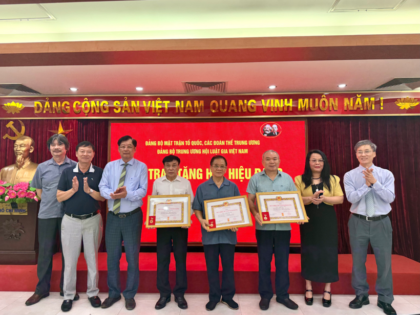 Lãnh đạo Hội Luật gia Việt Nam trao tặng Huy hiệu Đảng cho 3 đảng viên thuộc Đảng bộ và chụp ảnh lưu niệm.