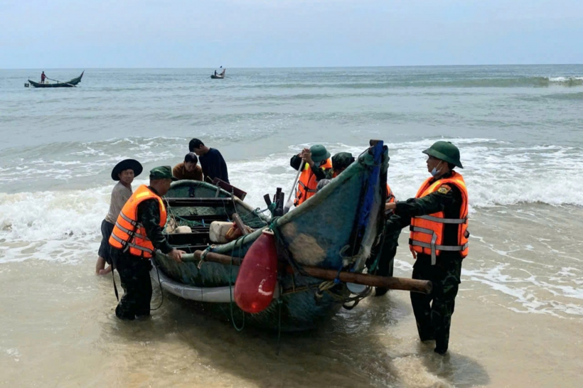 Lực lượng chức năng và người dân đưa ghe của ông Q. vào bờ (Ảnh: Đồn biên phòng Tam Thanh).