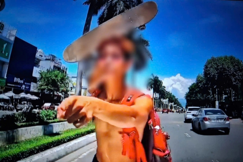 Người đàn ông cầm ván trượt đòi đập ô tô sau khi bị tài xế nhắc nhở. Ảnh: Dân Trí