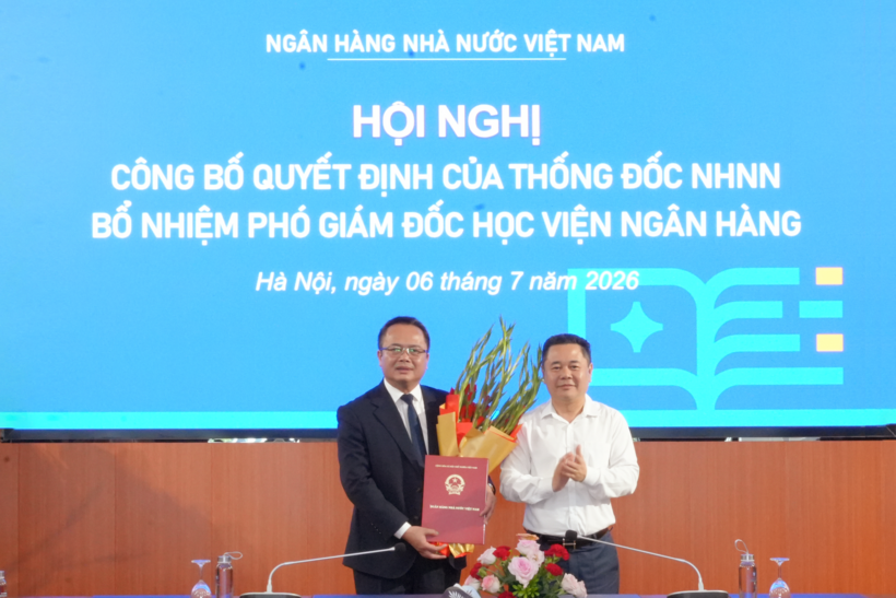 Phó Thống đốc Ngân hàng Nhà nước Việt Nam Nguyễn Ngọc Cảnh trao Quyết định và tặng hoa chúc mừng PGS.TS. Lê Ngọc Thắng (áo tối màu). Ảnh: Học viện Ngân hàng