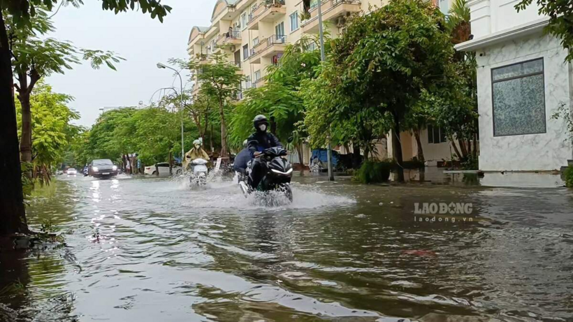 Đường Nguyễn Tất Tố cũng ngập sâu, có đoạn ngập ngang bánh xe máy khiến người dân khó khăn trong việc di chuyển. Ảnh: Mai Dung.