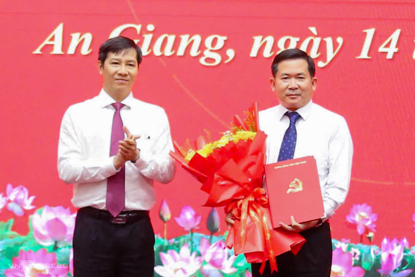 Ông Nguyễn Thành Tâm, Phó ban Tổ chức Trung ương (trái) trao quyết định và tặng hoa cho ông Đinh Văn Nơi. Ảnh: Dương Đông/ Theo VnExpress.