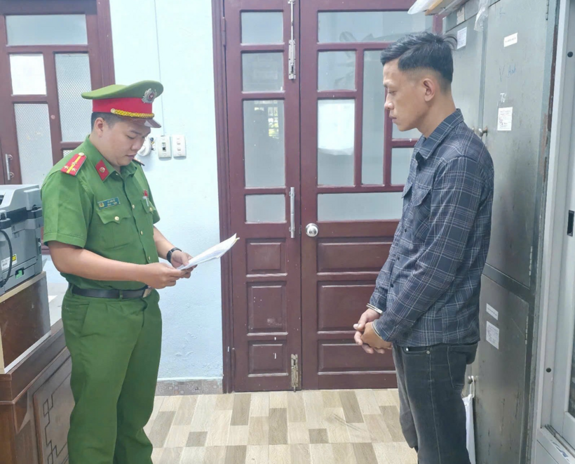 Cơ quan Công an tống đạt các quyết định đối với Lê Tấn Hùng. (Ảnh: Công an TP.Đà Nẵng)