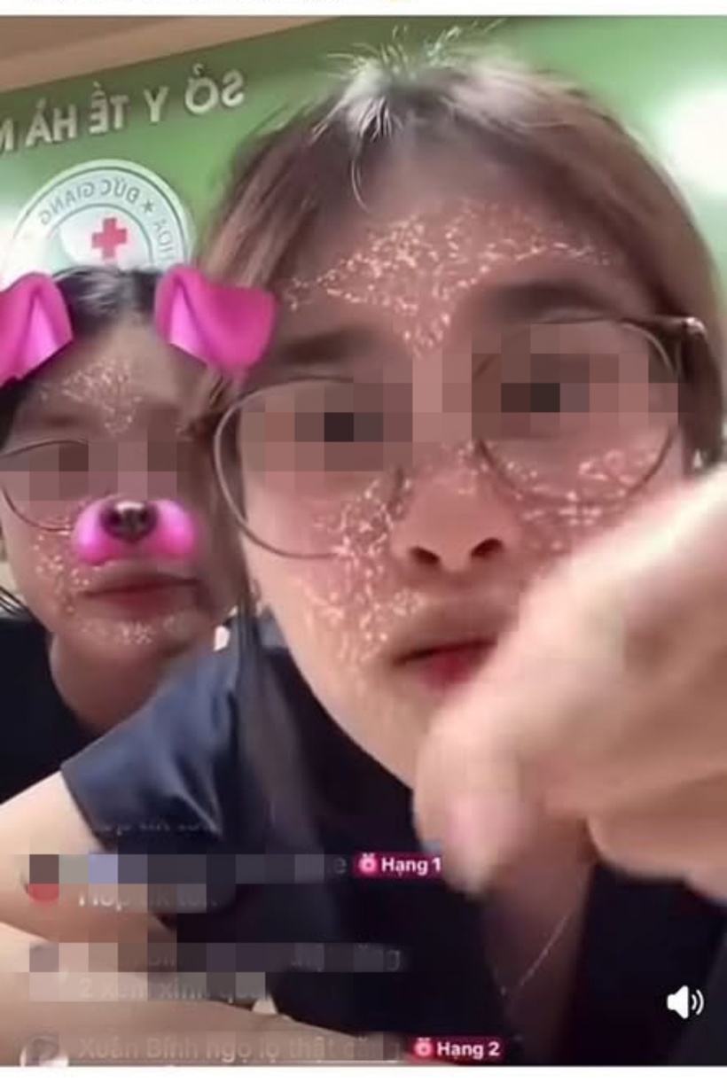 Hình ảnh hai nữ sinh ngồi tại quầy đón tiếp của Bệnh viện Đa khoa Đức Giang với phát ngôn và thái độ bị cho là thiếu chuẩn mực. Ảnh: Cắt từ clip
