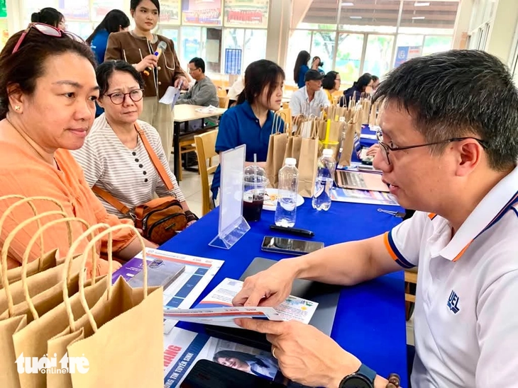 ThS Cù Xuân Tiến giải đáp thắc mắc của phụ huynh về phương thức xét tuyển tổng hợp Trường đại học Kinh tế - Luật áp dụng trong năm 2026 và cách tính điểm chuẩn của trường - Ảnh: TRẦN HUỲNH.