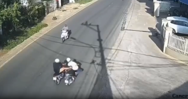 Ông Thuận (áo đen) đạp vào người ông Khanh đang đi xe máy khiến ông Khanh ngã xuống đường - Ảnh: Cắt từ clip/Tuổi Trẻ