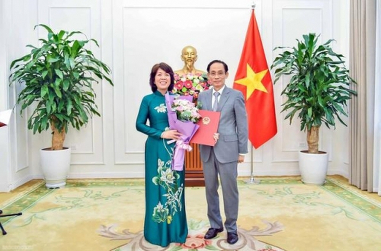 Bộ trưởng Bộ Ngoại giao Lê Hoài Trung trao quyết định của Thủ tướng Chính phủ và tặng hoa chúc mừng bà Nguyễn Thị Hoàng Vân được điều động, bổ nhiệm giữ chức Thứ trưởng Bộ Ngoại giao. Ảnh: VGP.
