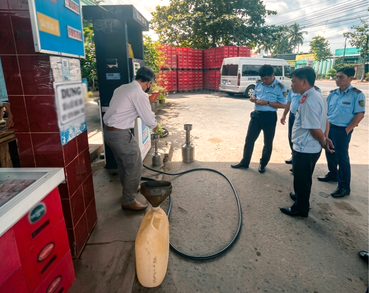 Lực lượng chức năng kiểm tra một cửa hàng xăng dầu - Ảnh: A.X./ Theo báo Tuổi trẻ.