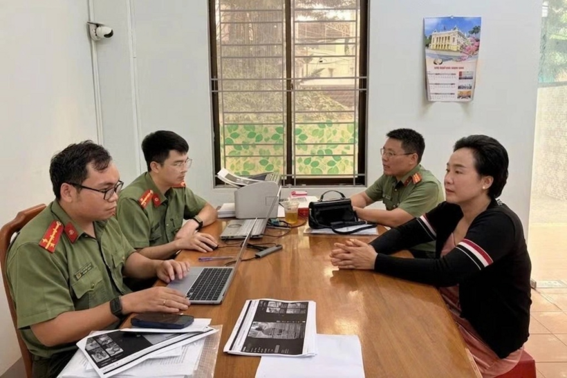 Phượng (áo đen) làm việc với cơ quan công an (Ảnh: Văn Ngọc).