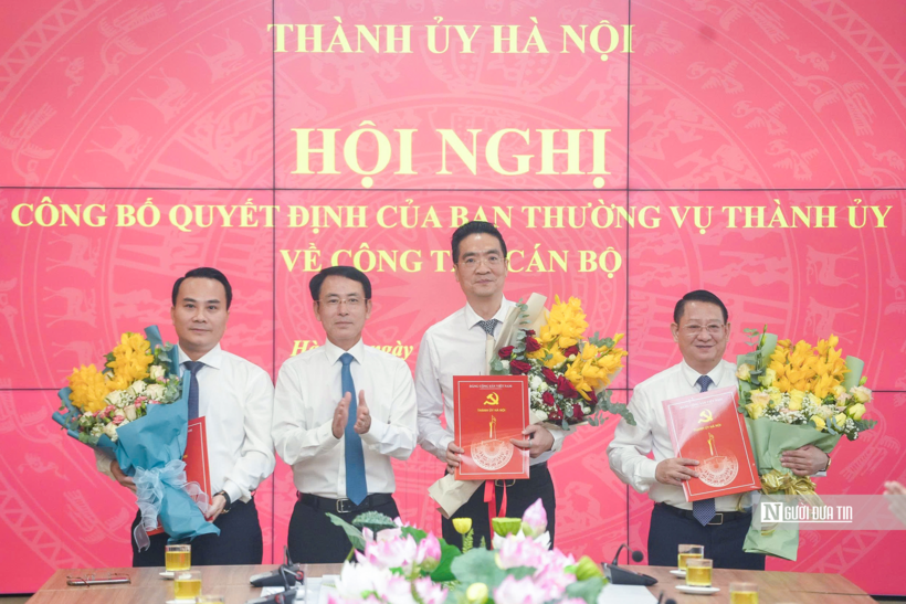 Phó Bí thư Thường trực Thành ủy Hà Nội Nguyễn Trọng Đông trao quyết định và tặng hoa chúc mừng tân Bí thư Đảng ủy phường Từ Liêm, xã Quang Minh và xã Tiến Thắng (Ảnh: Phạm Hùng).