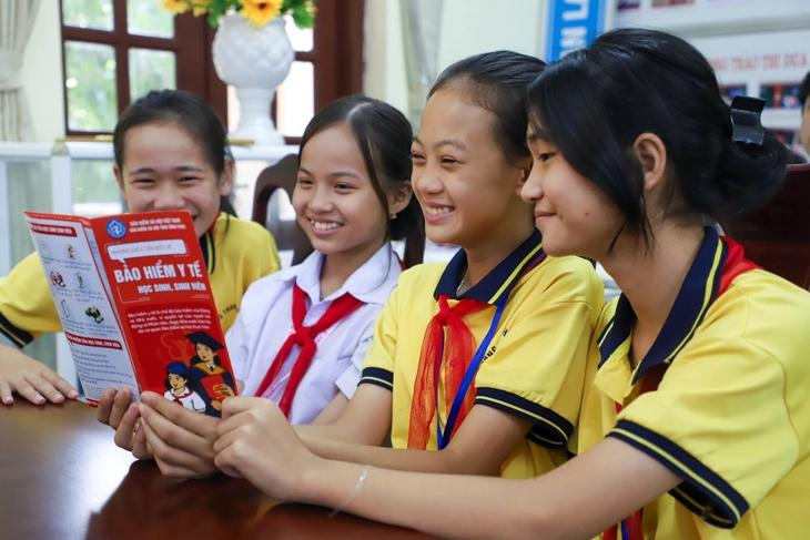Học sinh xem thông tin quyền lợi bảo hiểm y tế. Ảnh: Hà Quân/Tuổi trẻ Online