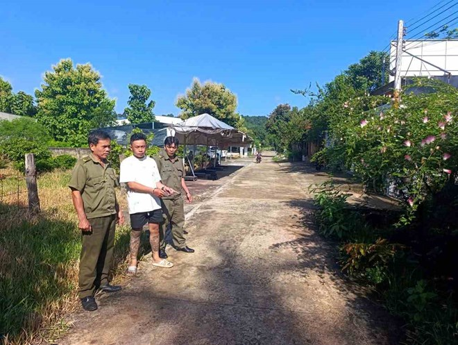 Đối tượng Nguyễn Minh Tú (áo trắng) bị bắt giữ được đưa trở lại hiện trường để điều tra làm rõ hành vi cướp giật tài sản. Ảnh: Công an phường Bình Long/Lao động