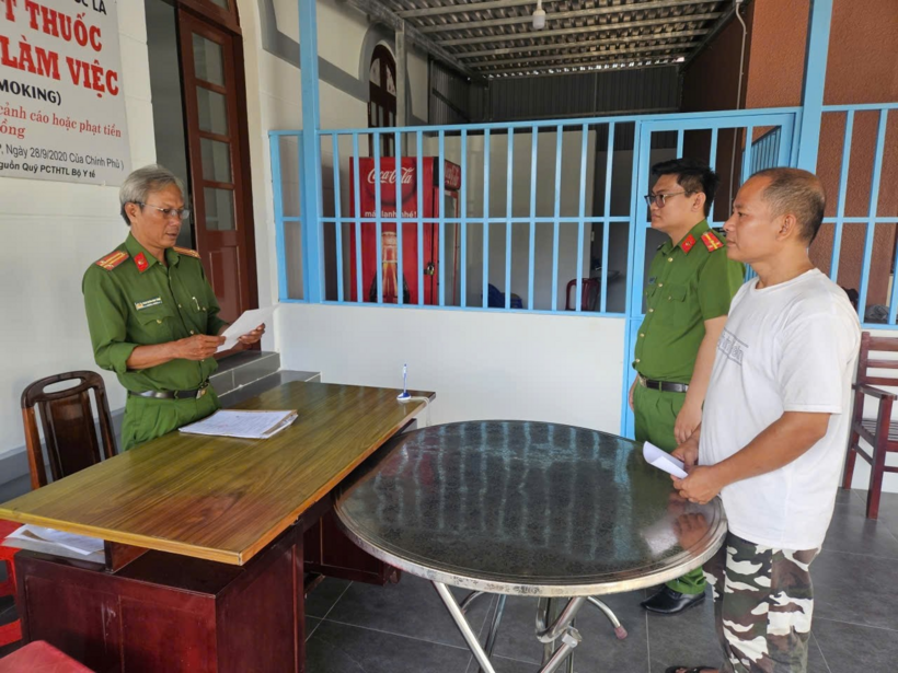 Cơ quan công an đọc quyết định tạm giữ hình sự đối với Đinh Văn Luyến (áo trắng). Ảnh: Thanh Niên