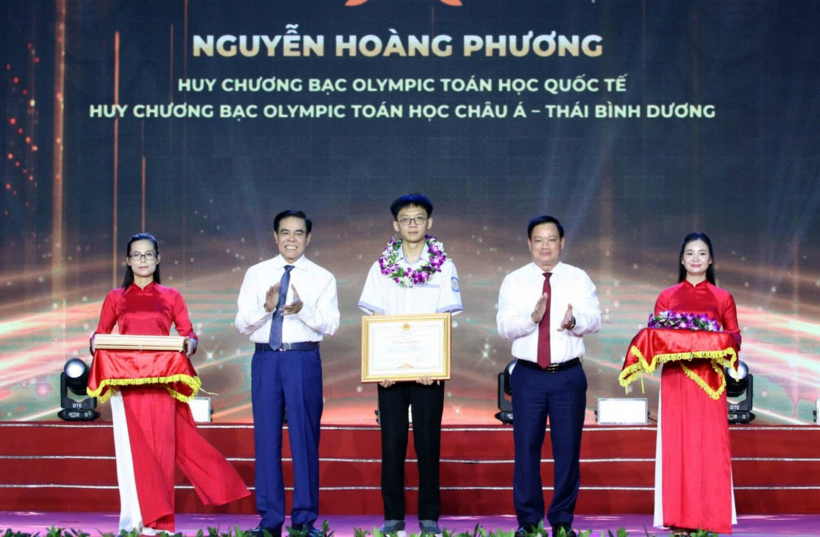 Ông Nguyễn Khắc Thận, Bí thư Tỉnh ủy Nghệ An và ông Võ Trọng Hải, Chủ tịch UBND tỉnh Nghệ An, trao bằng khen tới em Nguyễn Hoàng Phương. Ảnh: Kim Oanh/Dân trí