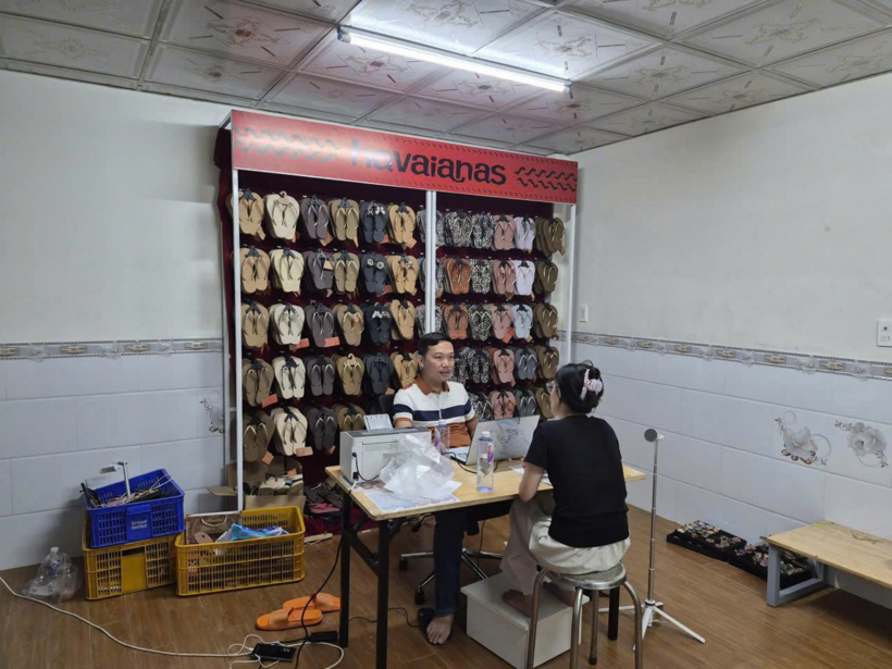 Cảnh sát kiểm tra kho hàng của hộ kinh doanh "Tiểu Vi House" phát hiện hoạt động kinh doanh, phân phối dép xỏ ngón mang nhãn hiệu "Havaianas" có dấu hiệu giả mạo - Ảnh: Công an TP.HCM/Tuổi Trẻ