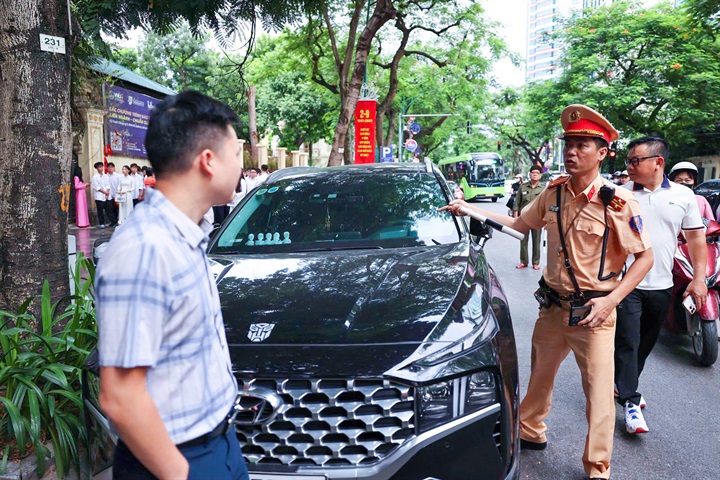 CSGT nhắc nhở các trường hợp dừng đỗ xe tại khu vực cổng Trường Trung học phổ thông Việt Đức.