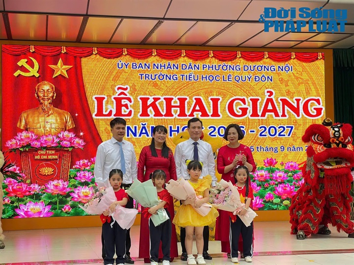 Chủ tịch UBND phường Dương Nội Phùng Chí Tâm (cà vạt đen thứ 3 từ trái qua) cùng học sinh tặng hoa cảm ơn thầy cô Trường Tiểu học Lê Quý Đôn nhân ngày khai trường.