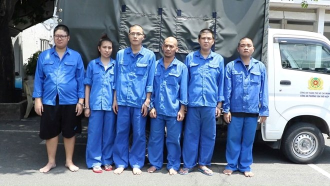 Các đối tượng trong đường dây bị cáo buộc dựng hồ sơ vay mua ôtô để chiếm đoạt tài sản tại cơ quan công an ngày 7/9. Ảnh: Công an TPHCM
