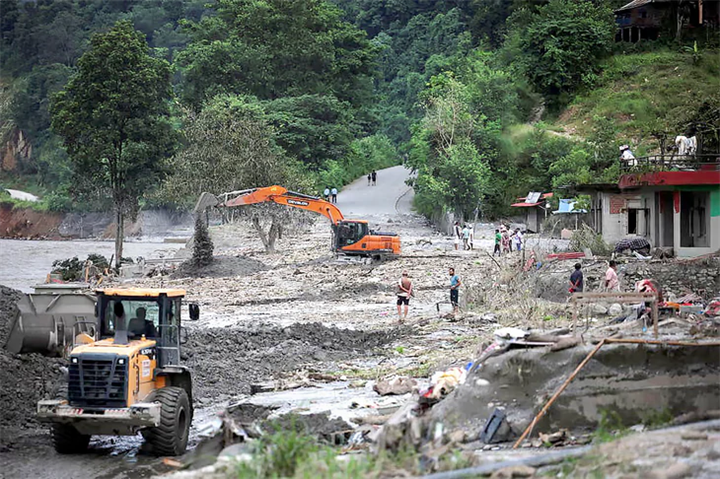 Một máy xúc đang sửa chữa đoạn đường bị hư hại ở Nepal, gần sông Trishuli, ngày 7/9. Ảnh: Reuters