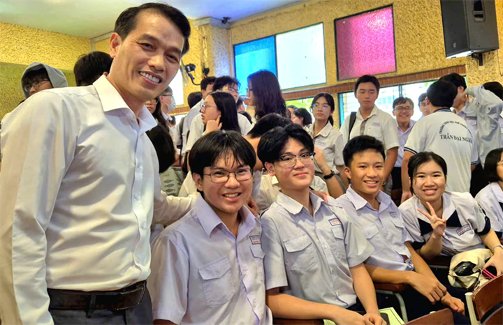 TS Nguyễn Minh, Hiệu trưởng Trường THPT chuyên Trần Đại Nghĩa và các học sinh của trường tại buổi lễ ra mắt đội tuyển đi thi học sinh giỏi quốc gia năm học 2025-2026. Ảnh: H.H/Tuổi Trẻ