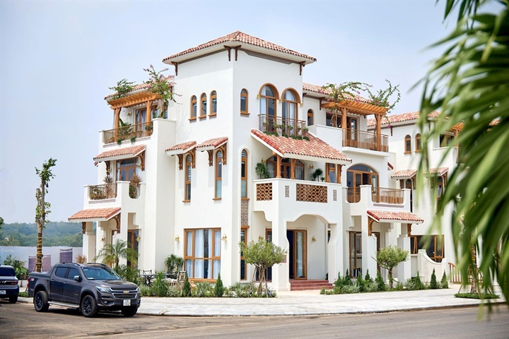 Đằng sau sắc trắng đặc trưng của những dãy nhà là một quy trình hoàn thiện được đầu tư kỹ lưỡng với hệ sơn theming 5 lớp phủ. Không chỉ tạo nên diện mạo đồng nhất, tinh tế, hệ sơn nhiều lớp còn góp phần bảo vệ bề mặt công trình trước tác động của nắng, gió và hơi muối, giúp vẻ ngoài của những căn nhà duy trì độ bền đẹp theo thời gian. Ảnh: Ánh Dương