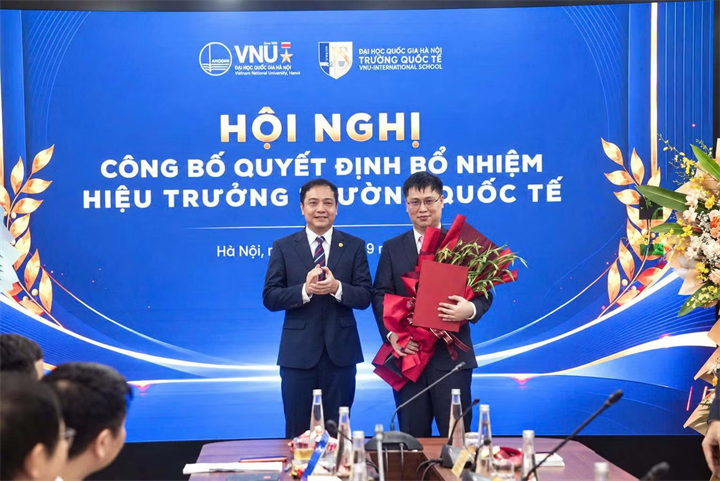 PGS.TS Đào Thanh Trường, Phó Giám đốc ĐHQGHN trao quyết định và chúc mừng PGS.TS Nguyễn Anh Tuấn, tân Hiệu trưởng Trường Quốc tế. Ảnh: Công an Nhân dân