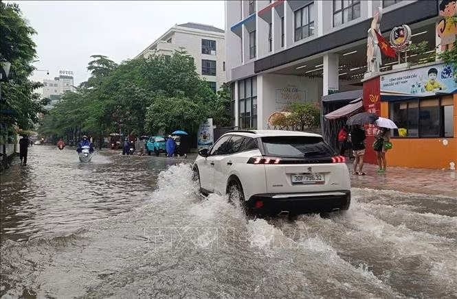 Mưa lớn khiến nhiều điểm trên phố Triều Khúc bị ngập. Ảnh: Nguyễn Thắng/TTXVN