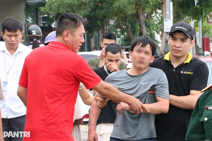Chủ gara thất thần, được dìu ra khỏi hiện trường vụ cháy (Ảnh: Hoàng Lam)/Dân Trí