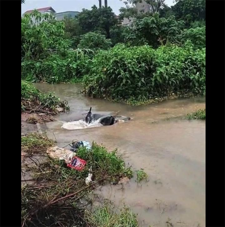 Vị trí người dân phát hiện chiếc xe Honda biển số Nam Định (cũ) của nam sinh viên nằm ở miệng cống thoát nước nhưng không thấy người. Ảnh cắt từ clip./ Theo VietNamNet.