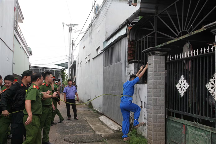 Nguyễn Đức Anh thực nghiệm quá trình leo rào lên mái nhà nạn nhân. Ảnh: Tiền Phong.
