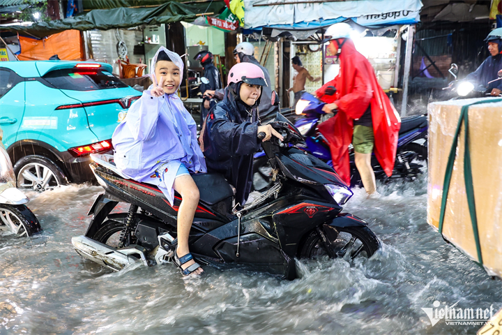 Mưa lớn ở TP.HCM chiều ngày 22/9, phụ huynh và học sinh vật lộn về nhà. Ảnh: Nguyễn Huế/VietNamnet