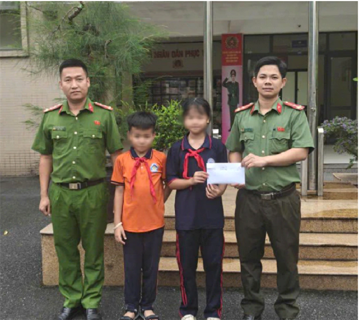 Hai cháu nhỏ giao nộp số tiền lớn đã nhặt được cho cơ quan Công an. Ảnh: Công an Hà Nội.