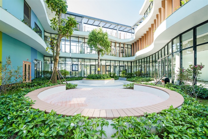 Bước qua cổng Vin Nexus Center, điều dễ nhận thấy là từ hành lang, lớp học đến những khoảng sinh hoạt chung đều khoác lên mình một bảng màu nhạt, ấm và dịu, thay cho các gam màu mạnh thường thấy ở trường học thông thường. Sự “lạ” ấy không bắt đầu từ mong muốn tạo ra một ngôi trường đẹp, mà từ một câu hỏi thực tế: “Làm thế nào để không gian không trở thành một nguồn gây quá tải giác quan cho trẻ?”, ThS giáo dục Nguyễn Ngọc Minh, Phó Tổng giám đốc Khối Học thuật Vinschool, Giám đốc dự án Vin Nexus Center chia sẻ.