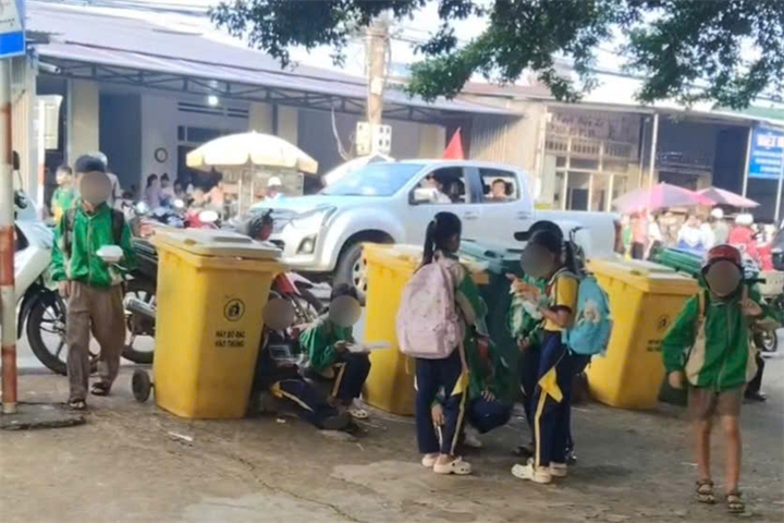 Học sinh Trường Tiểu học và THCS Lê Lợi ngồi ăn sáng cạnh thùng rác. Ảnh: Dân trí