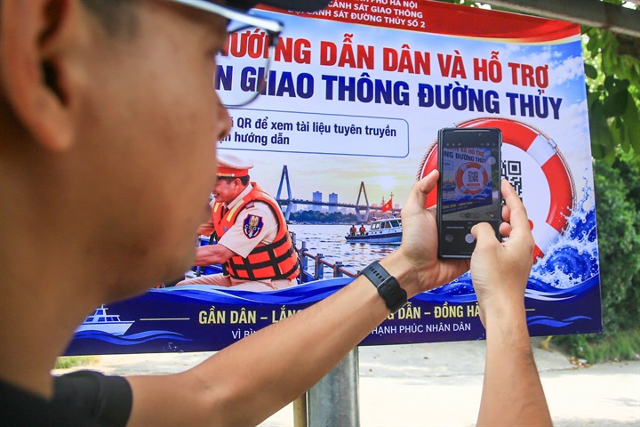 Người dân sử dụng điện thoại quét mã QR để cập nhật thông tin pháp luật.