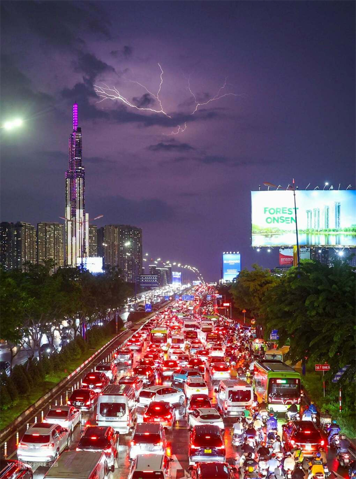 Tia sét trên bầu trời trung tâm TP.HCM, bên trái là tòa nhà Landmark 81 tầng, nhìn từ cầu bộ hành ga metro Thảo Điền, tối 1/10. Ảnh: Quỳnh Trần/VnExpress