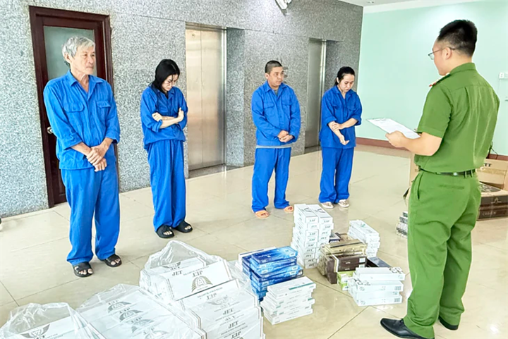 Cơ quan điều tra đọc quyết định khởi tố 4 trong số 6 người về hành vi buôn bán hàng cấm là thuốc lá điếu nhập lậu - Ảnh: SỸ ĐỨC