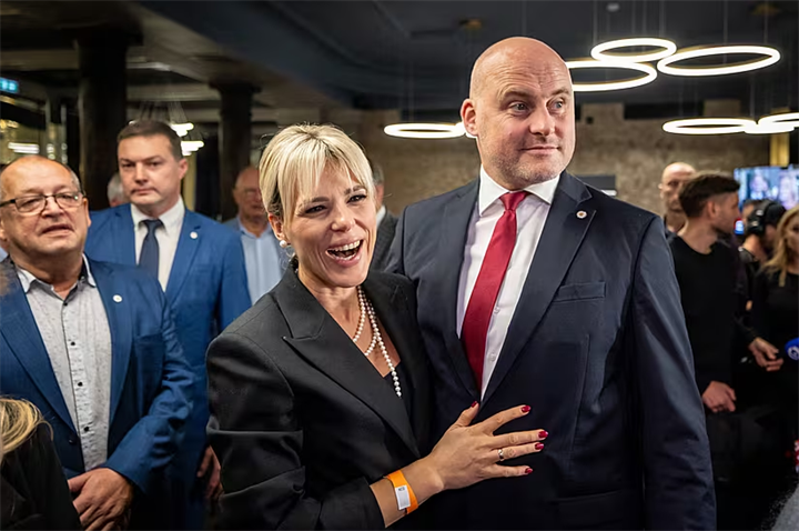 Thủ tướng Latvia Andris Kulbergs và phu nhân Anna phản ứng sau khi kết quả thăm dò cử tri rời phòng bỏ phiếu đầu tiên (exit poll) của cuộc tổng tuyển cử được công bố. Ảnh: BreakingNews.ie