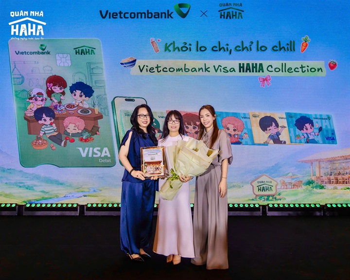 Bà Đoàn Hồng Nhung - Thành viên BĐH, Giám đốc Khối Bán lẻ Vietcombank (ở giữa) đại diện ngân hàng nhận hoa và biểu trưng từ đơn vị sản xuất tại họp báo ra mắt Quán Nhà Haha
