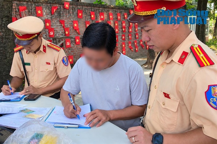 Lực lượng chức năng lập biên bản đối với tài xế vi phạm. Ảnh: Khánh Phương