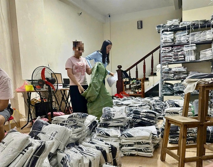 Lực lượng QLTT số 13 kiểm tra số hàng hóa có dấu hiệu giả mạo nhãn hiệu Adidas tại cơ sở kinh doanh. Ảnh: QLTTHN