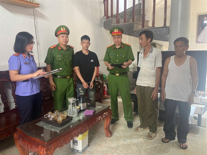 Cơ quan chức năng công bố quyết định khởi tố vụ án, khởi tố bị can đối với Nguyễn Tuấn Anh (áo đen). Ảnh Công an tỉnh Phú Thọ.