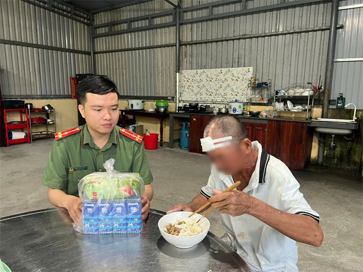 Cán bộ công an xã chăm sóc người đàn ông đi lạc. Ảnh: Lao động
