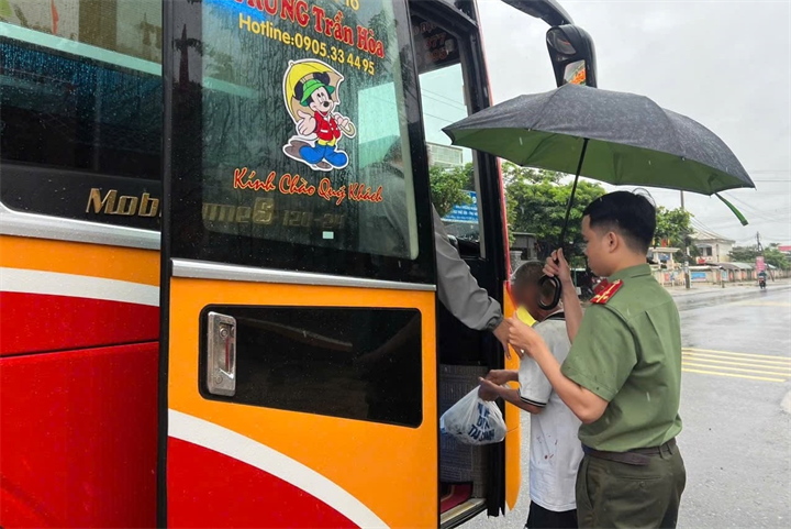 Công an xã Điện Bàn Tây hỗ trợ người đàn ông lên xe khách trở về với gia đình. Ảnh: VietNamnet