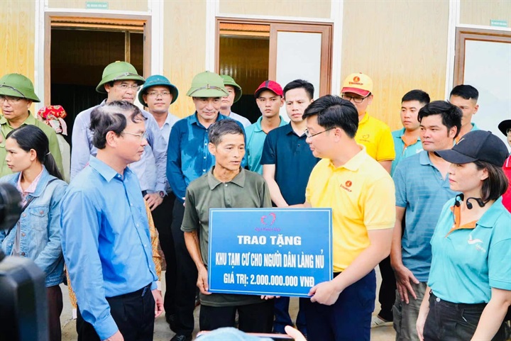 Đại diện Quỹ Thiện Tâm thăm hỏi, động viên và trao biển tượng trưng khu nhà tạm cho người dân bị mất nhà vì lũ quét ở làng Nủ. Nguồn ảnh Vingroup