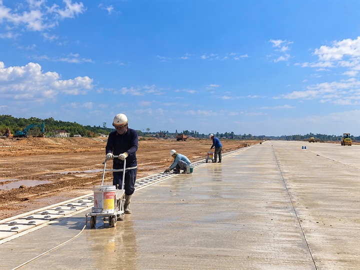 Công nhân lấy dấu sơn kẻ hoàn thiện đường cất hạ cánh. Ảnh: Anh Chiến