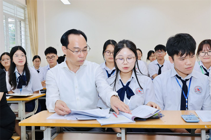 Bộ trưởng Hoàng Minh Sơn trò chuyện với học sinh Trường THPT Chuyên Hạ Long, Quảng Ninh. Ảnh: MOET
